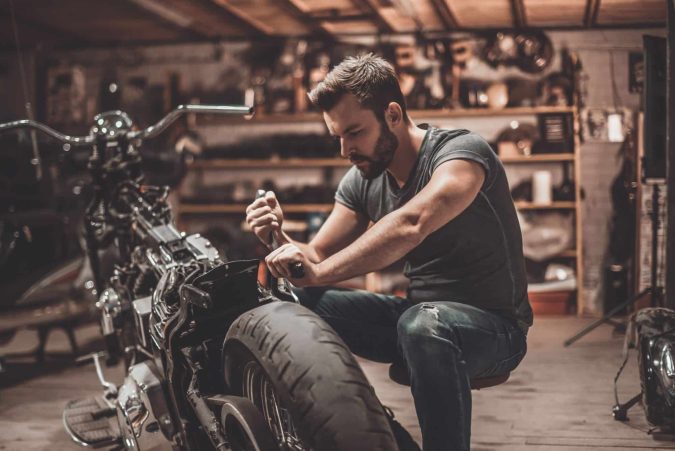 Rider modifying his bike with aftermarket parts