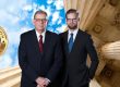 Two men in suits stand by columns, with a "100% Satisfaction Guaranteed" badge floating in the sky. Trust a Lansing Personal Injury Lawyer to back that promise, ensuring you receive the dedication and expertise needed for your case.