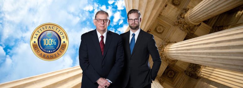 Two men in suits stand by columns, with a "100% Satisfaction Guaranteed" badge floating in the sky. Trust a Lansing Personal Injury Lawyer to back that promise, ensuring you receive the dedication and expertise needed for your case.