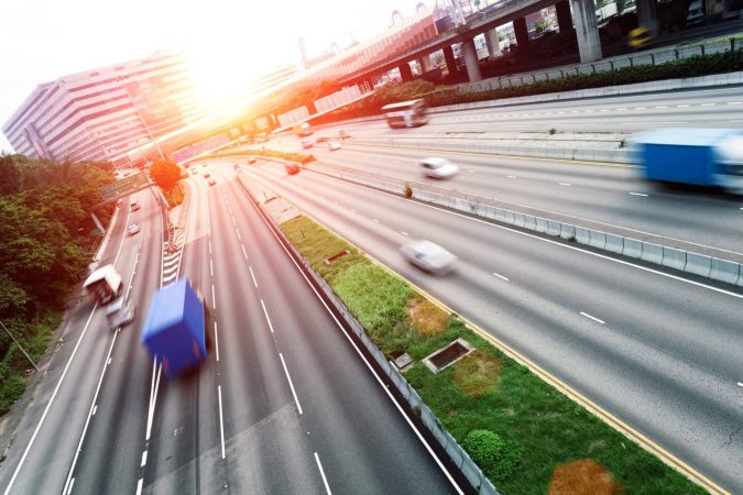 busy traffic on multi highway lanes during sunset.