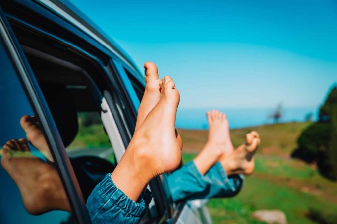 The Risks and Legalities of Putting Your Feet Out the Window as a Passenger Kids putting their feet out of a car window