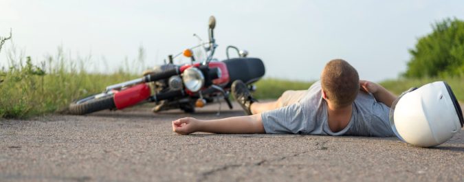 A motorcycle accident in Lansing has left a person lying on the road next to their fallen bike, with a helmet scattered nearby, highlighting the severe potential for injuries in such incidents.