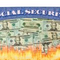 A Social Security card with US dollar bills on it appears to be burning at the bottom with visible flames.