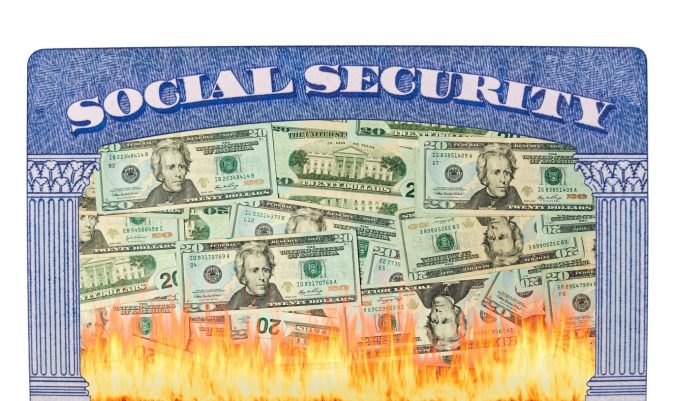 A Social Security card with US dollar bills on it appears to be burning at the bottom with visible flames.
