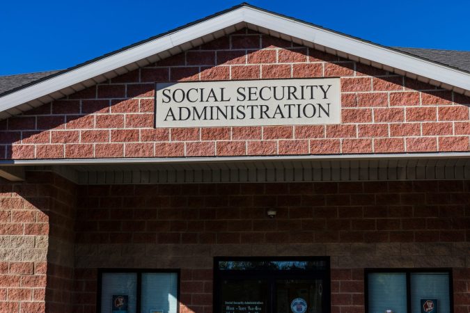 A brick building with a sign above the entrance that reads "Social Security Administration" against a clear blue sky.