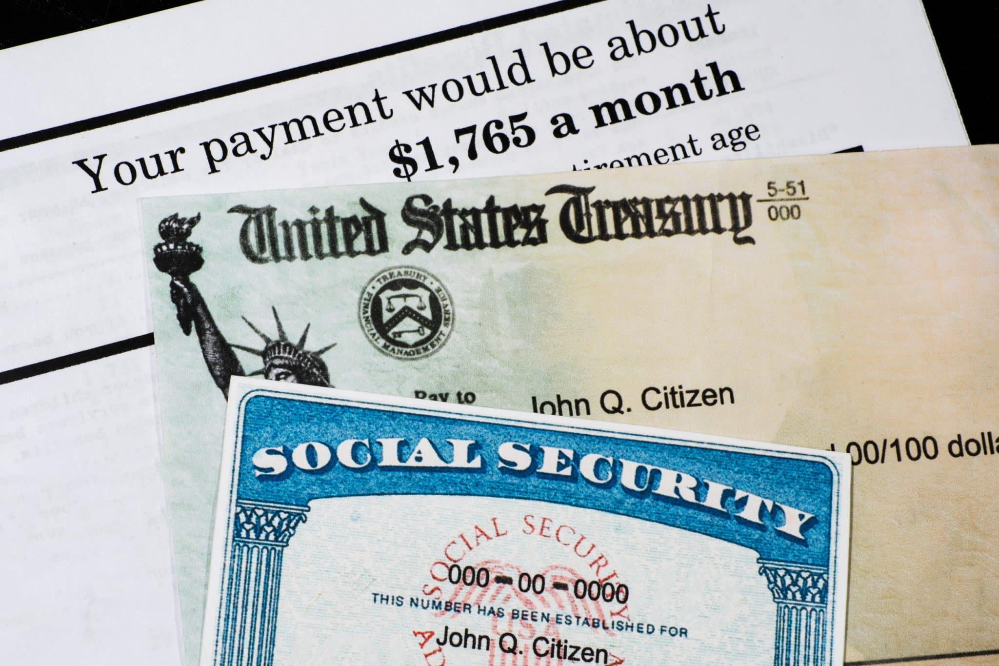 A Social Security card and a U.S. Treasury check are placed on top of a document showing a monthly payment amount of $1,765.