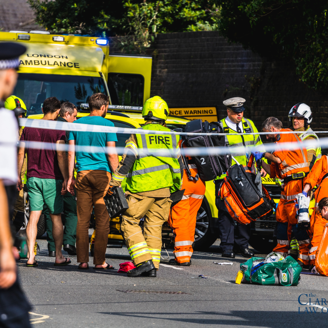 Emergency responders assist several people at the scene of an incident on a city street, with a fire truck and ambulance visible in the background. Emergency responders assist several people at the scene of an incident on a city street, with a fire truck and ambulance visible in the background.
