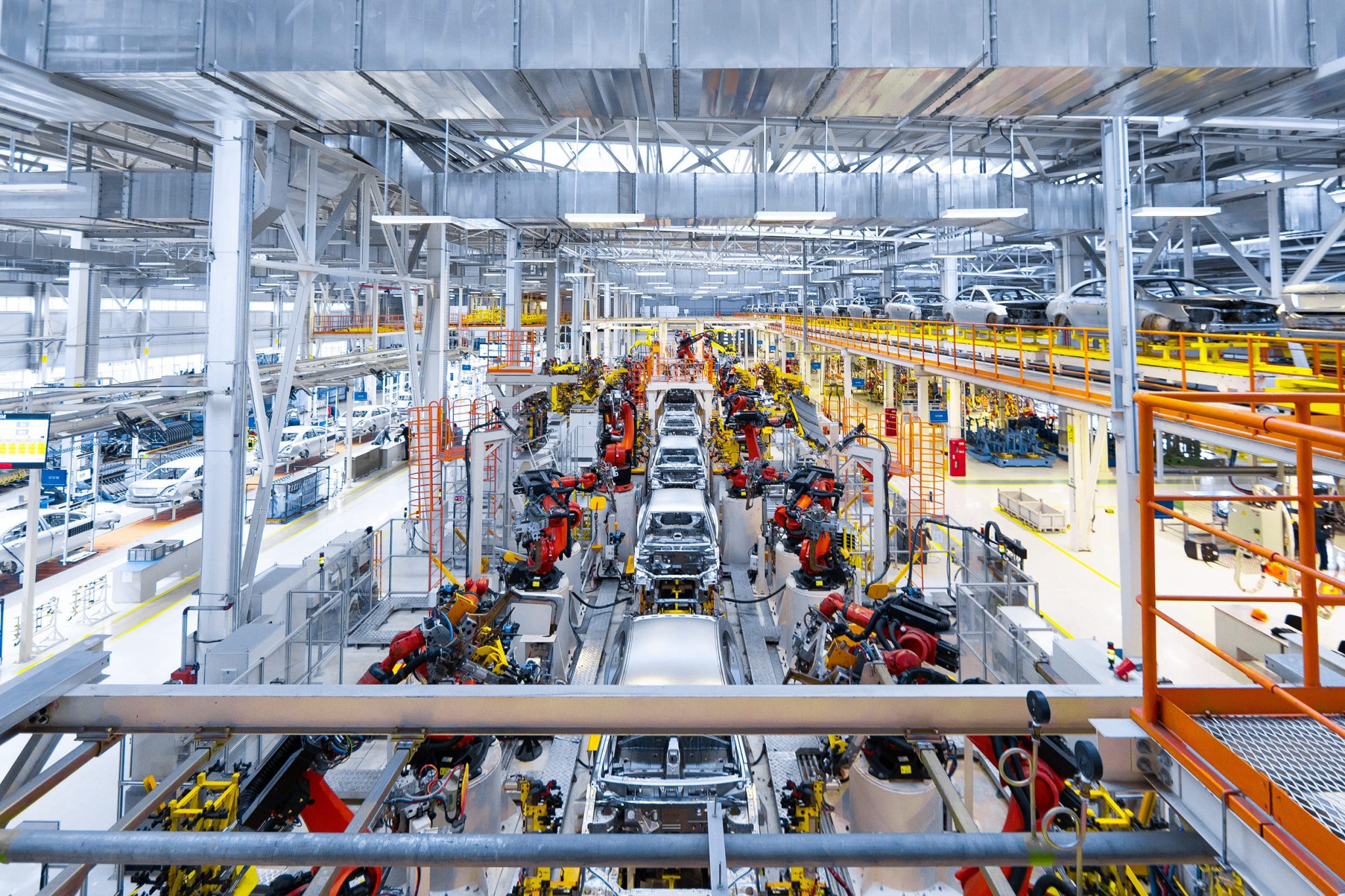 Automotive factory assembly line with industrial machinery and robotic arms